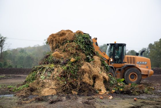 A bulldozer moving a large pile of dirt. 
